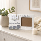 Kiddospot wooden baby reveal calendar displayed on a nursery dresser with eucalyptus plant and muslin wrap