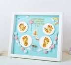 Baby milestone shadow box with hand and footprints on a light blue background