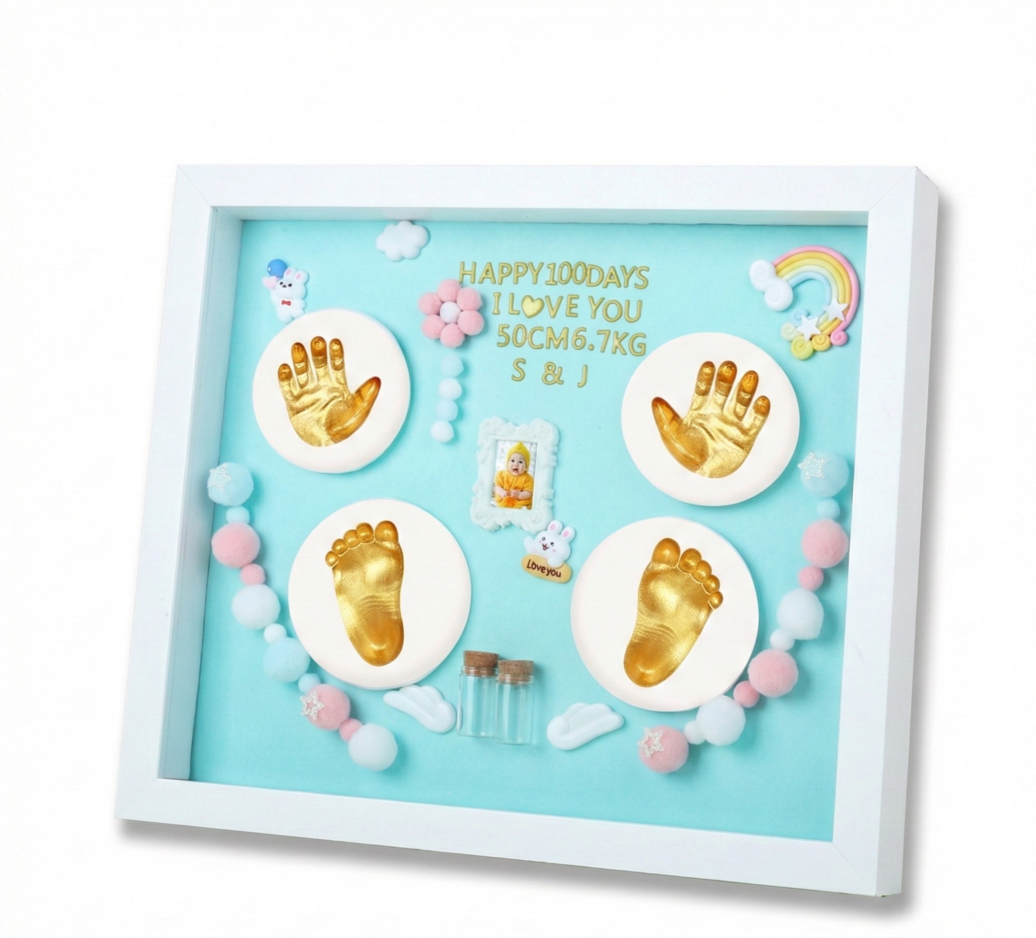 Decorative shadow box with gold hand and footprints on a light blue background