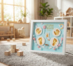 Decorative frame with hand and footprints on a rug in a room with plants and furniture.