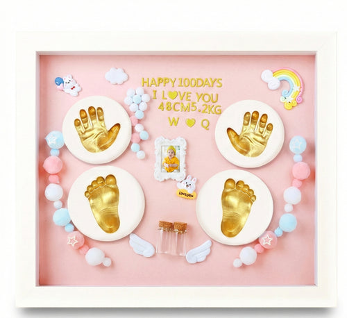 Decorative shadow box with gold hand and footprints, colorful beads, and baby-themed elements on a pink background.