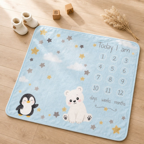 Kiddospot blue baby milestone blanket with penguin and bear design on a wooden floor.