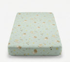 Floral-patterned mattress cover on a light green background