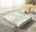 Folded crib mattress with frog design on a fluffy rug