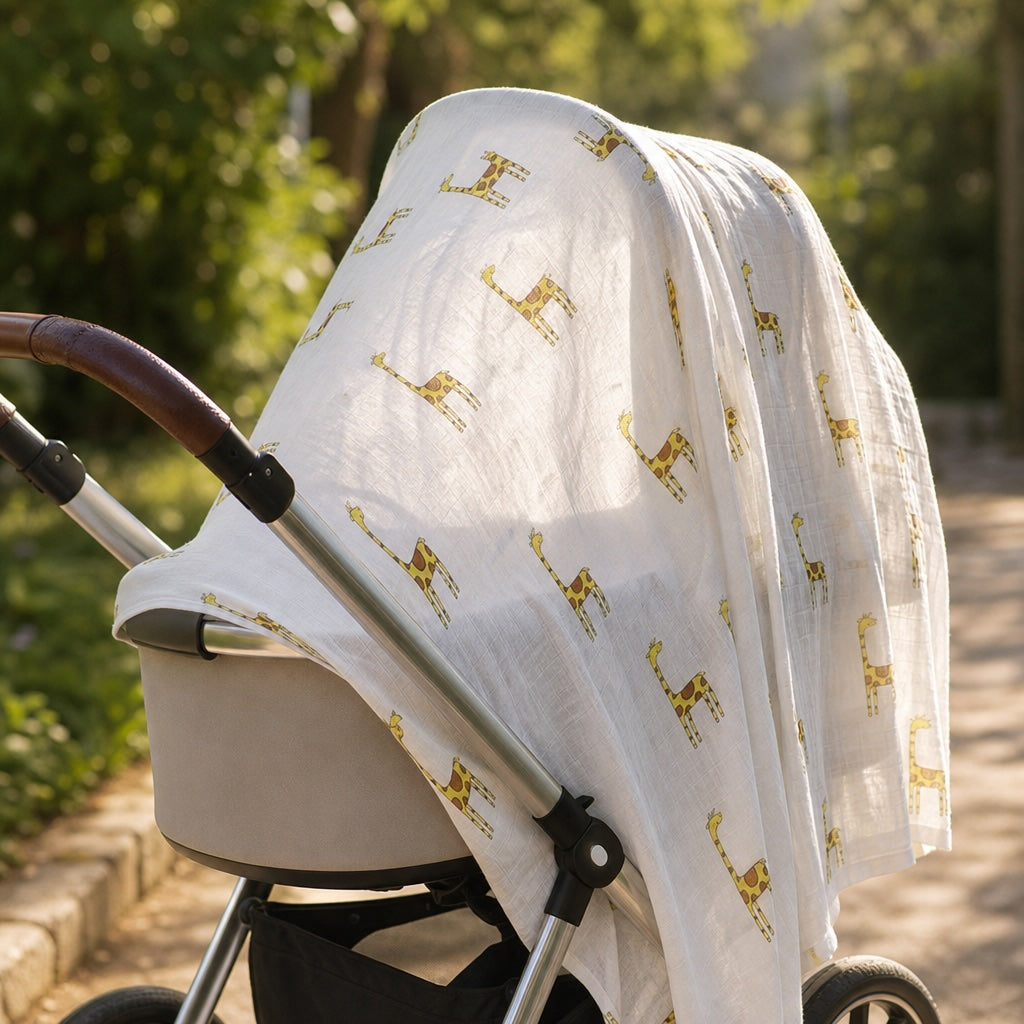 Baby stroller with a white canopy featuring Kiddospot GOTS Organic Muslin Swaddle in Giraffe Print.