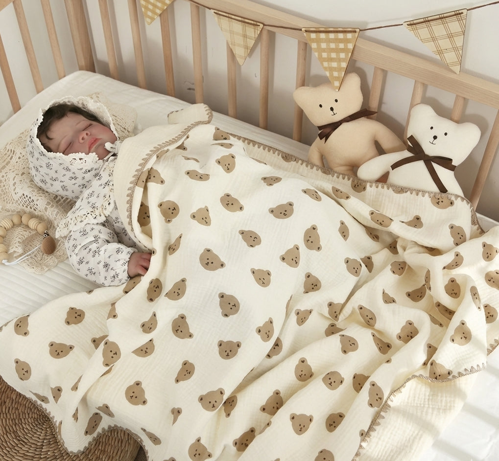Baby sleeping in a crib with a teddy bear patterned blanket and toys.