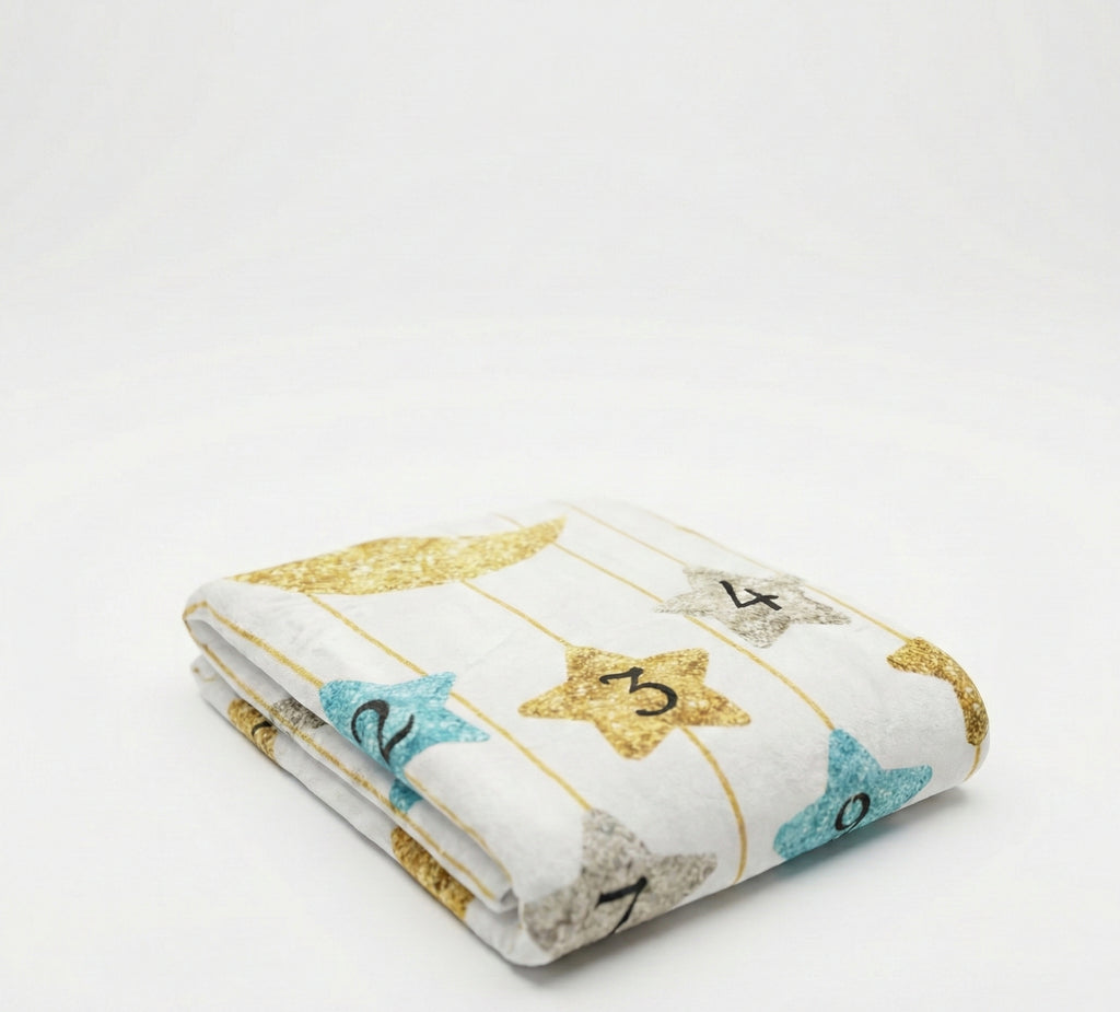 Folded baby blanket with star patterns and numbers on a white background