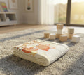Folded blanket with a fox design on a carpeted floor with wooden blocks.
