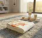 Folded blanket with a fox design on a carpeted floor with wooden blocks.