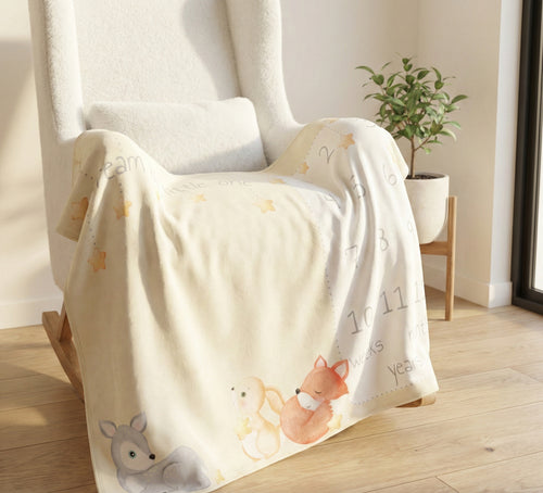 Baby blanket with animal illustrations draped over a chair in a room.