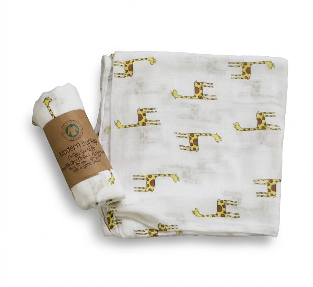 Baby blanket with giraffe pattern and rolled-up diaper on a white background
