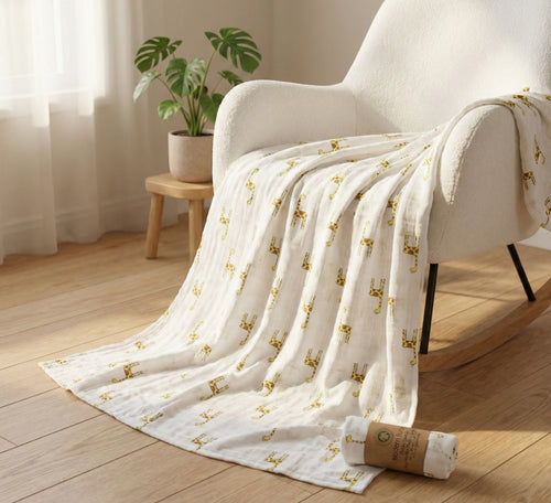 Kiddospot organic muslin swaddle giraffe print draped over nursery chair — GOTS certified