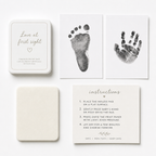 Baby hand and foot print kit with inkless pad, prints, and instructions on a white background