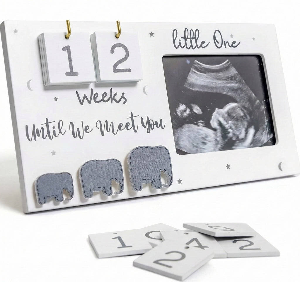 Baby countdown calendar with ultrasound photo and elephant cutouts on a white background