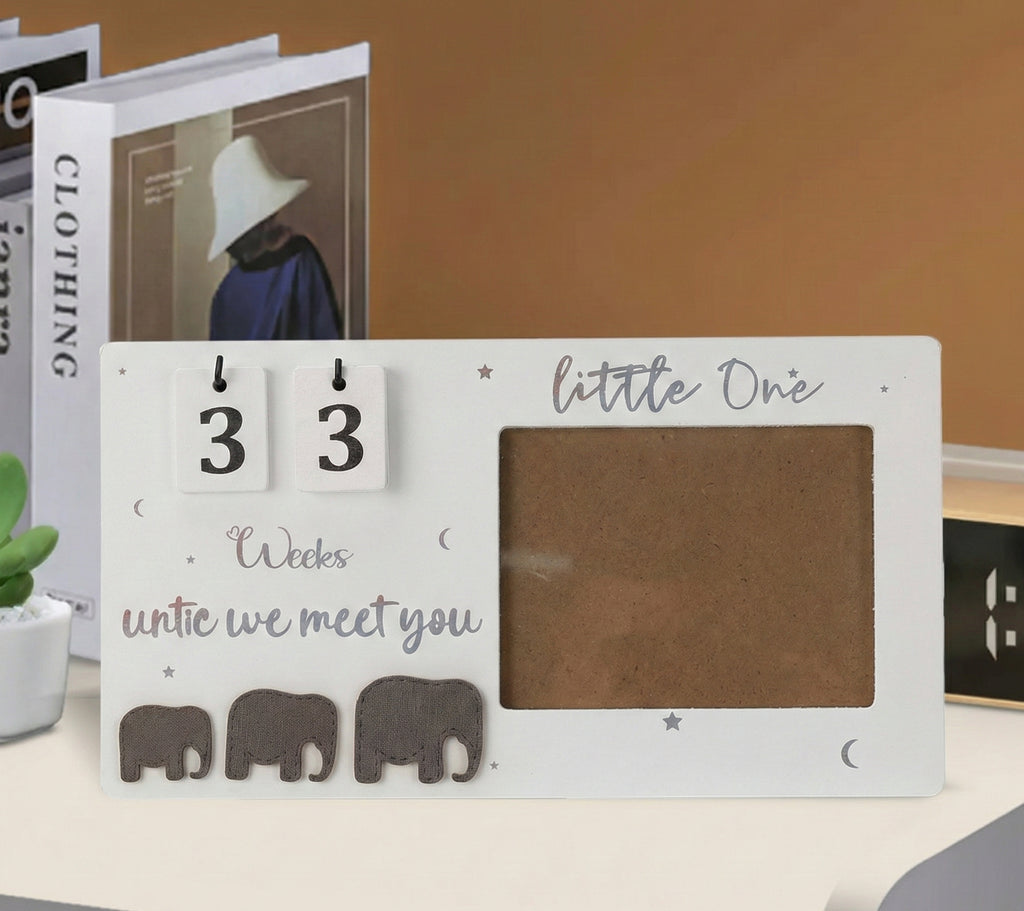 Baby milestone card with elephants and text on a surface
