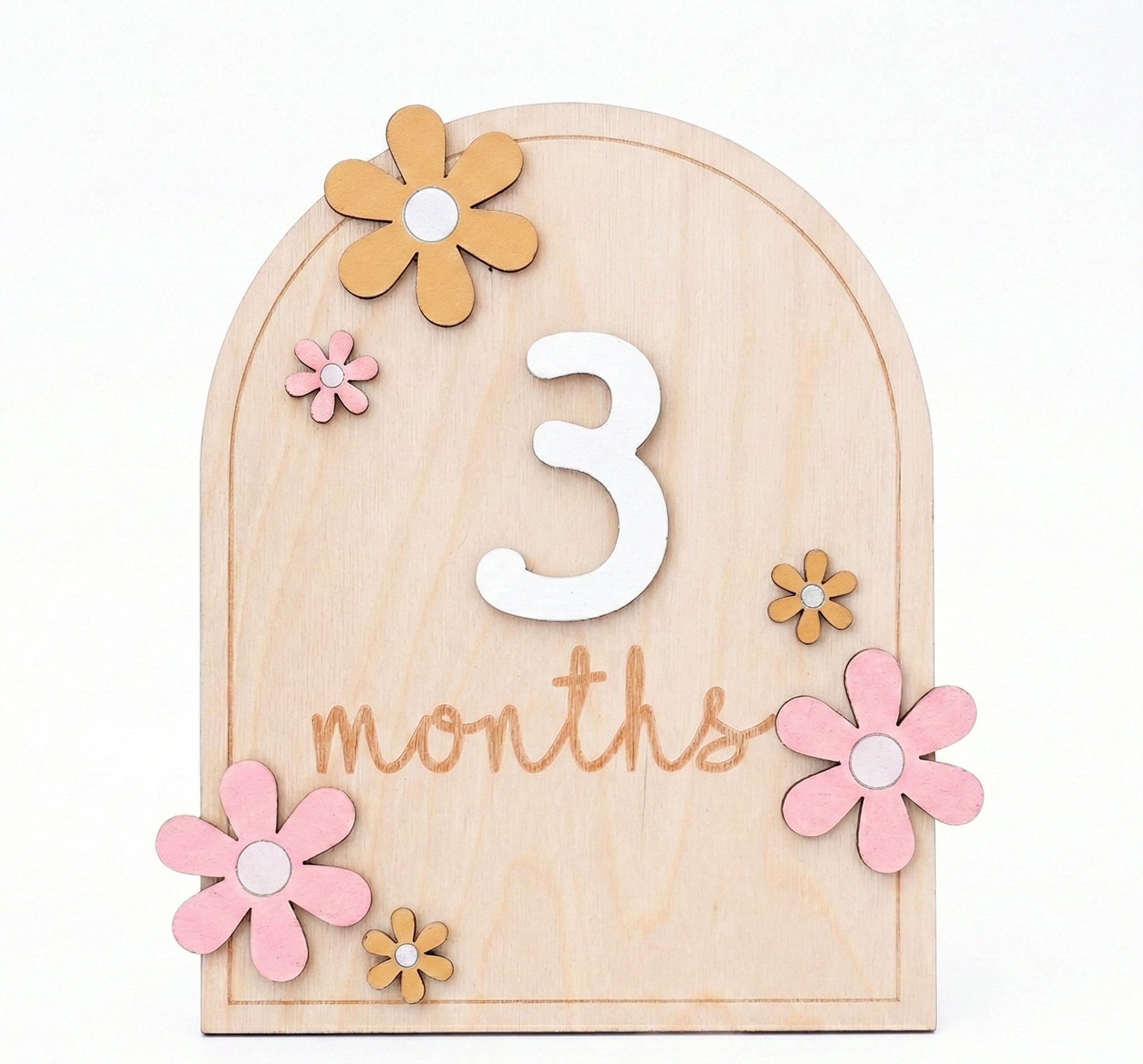 Wooden milestone with flowers and the number '3' on a white background