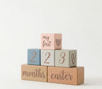 Stack of baby blocks with milestone text on a white background