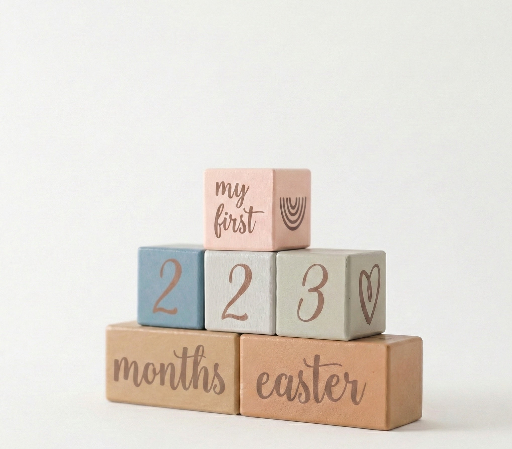 Stack of baby blocks with milestone text on a white background