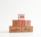 Stack of wooden blocks with '570 days easter' text on a white background