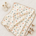 Organic baby blanket heart design, GOTS-certified cotton knit, styled with cream booties and cotton bolls