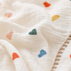 Close-up of GOTS organic cotton knit texture on heart design baby blanket with stitched border