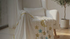 Kiddospot White Baby Milestone Blanket — crisp ivory base with gold glitter crescent moon, twelve numbered gold, silver-grey and teal stars on a shimmering gold wreath border, and "Today I am" milestone tracking text for Weeks 1–4 and Months 1–12. 100x150cm ultra-soft high-pile flannel fleece. Gender-neutral, timeless design. Perfect monthly baby photo prop and baby shower gift. Free AU shipping. kiddospot.com