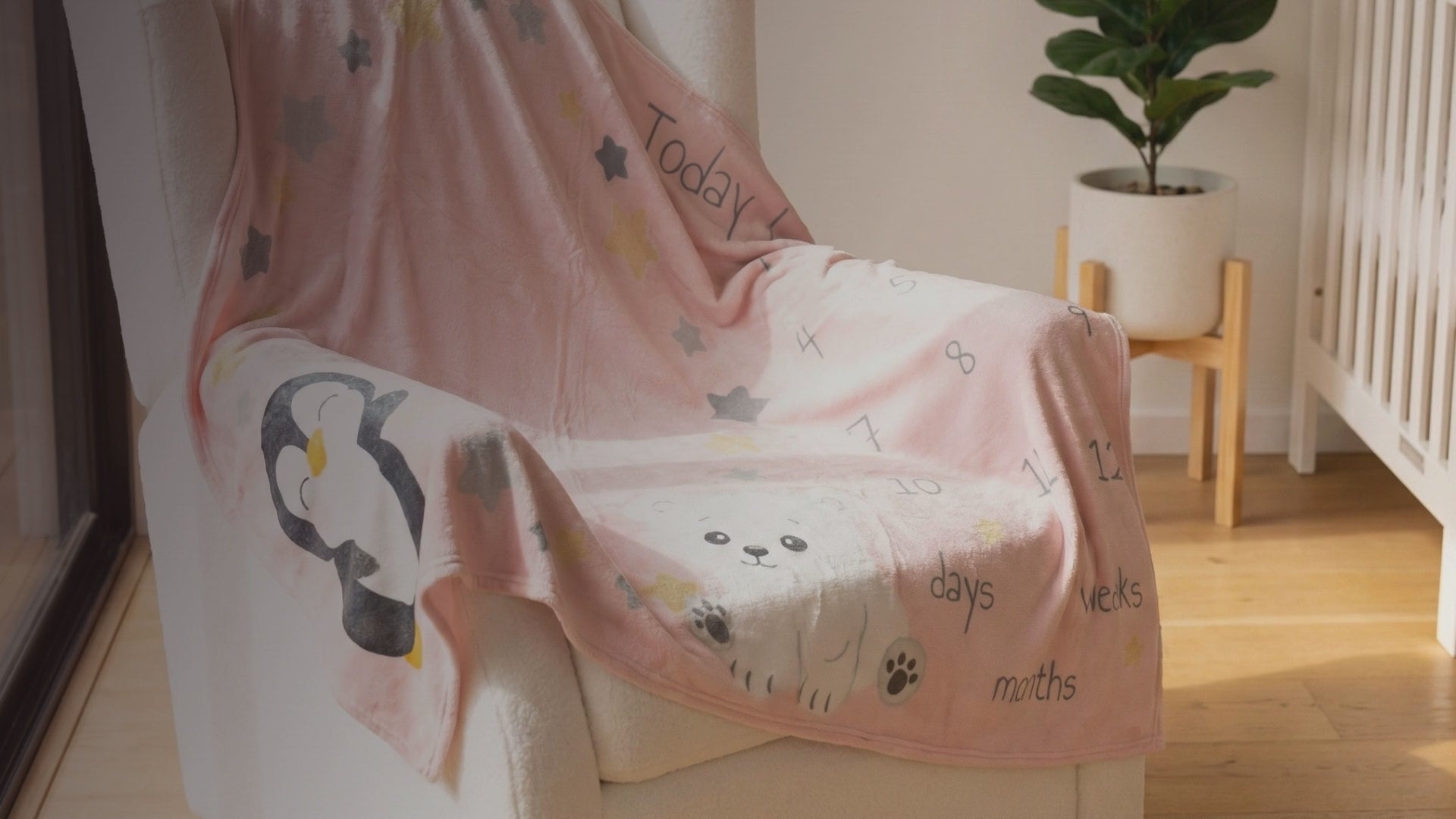 Kiddospot Pink Baby Milestone Blanket — soft blush pink base with kawaii polar bear, penguin, scattered shimmering gold and charcoal grey stars, and "Today I am" milestone tracking text for Weeks 1–4 and Months 1–12. 100x150cm ultra-soft high-pile flannel fleece. Perfect monthly baby photo prop and baby shower gift. Free AU shipping. kiddospot.com