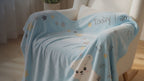 Kiddospot Blue Baby Milestone Blanket — pale sky blue base with kawaii polar bear, penguin, scattered gold and grey stars, white clouds, and charcoal grey "Today I am" milestone tracking text for Weeks 1–4 and Months 1–12. 100x150cm ultra-soft high-pile flannel fleece. Perfect monthly baby photo prop and baby shower gift. Free AU shipping. kiddospot.com