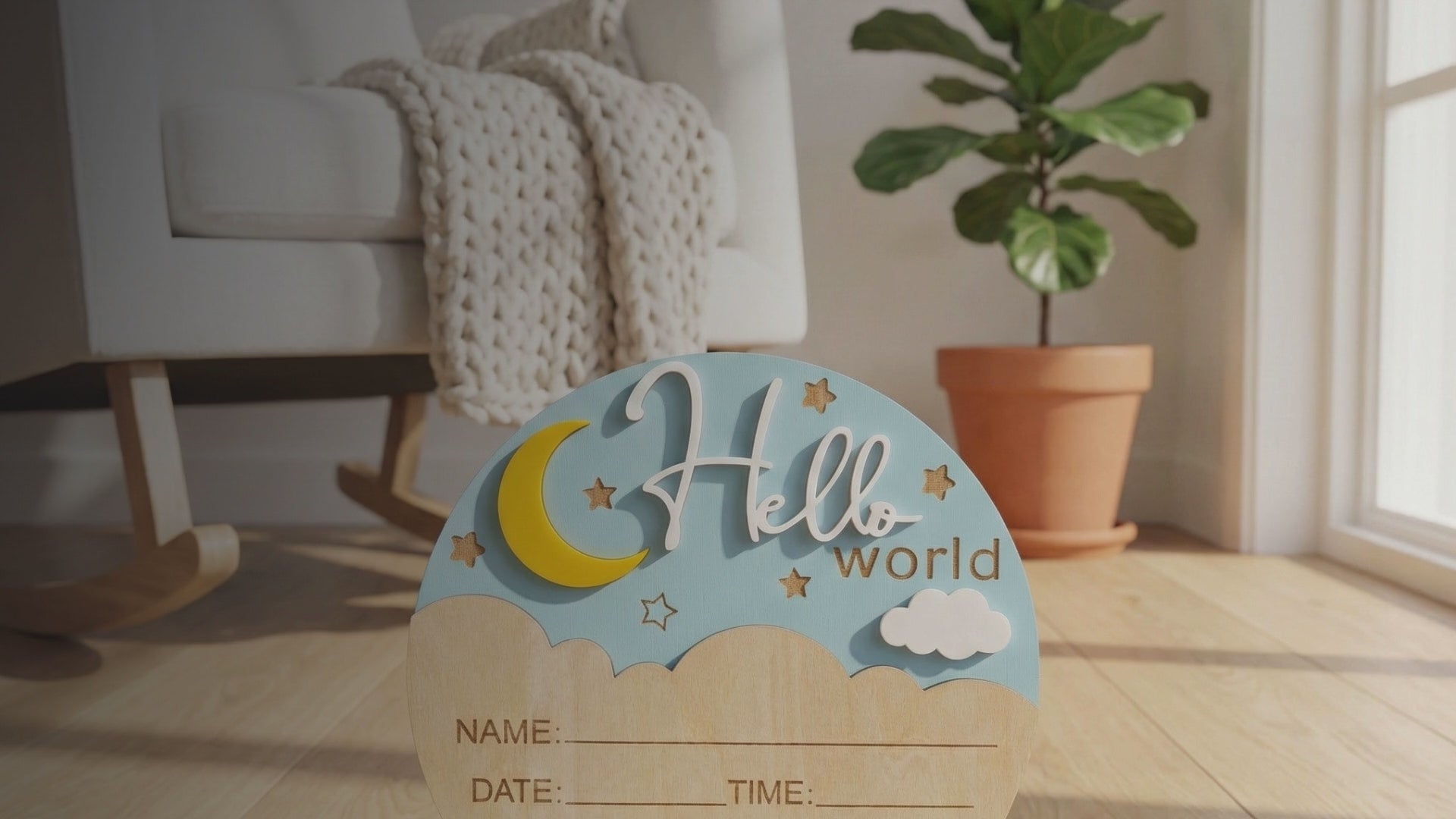Kiddospot Wooden Hello World Baby Announcement Sign — circular natural birch plaque with a pastel blue sky top half, 3D golden crescent moon, white raised script "Hello" and laser-engraved "world", scattered star engravings, and a natural wood cloud-shaped bottom section with engraved fields for name, date, time, weight and length. AS/NZS certified. Perfect newborn photo prop and permanent birth keepsake. Free AU shipping. kiddospot.com
