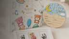 Kiddospot First Memories Gift Set — includes 100-page guided baby memory book and journal with gold foil hardbound cover, newborn mess-free inkless hand and footprint kit, and wooden Hello World birth announcement sign. Complete newborn keepsake bundle, ISO 8124 certified, arrives gift-boxed. Free AU shipping. kiddospot.com
